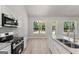 Kitchen featuring granite counters, stainless appliances, view of backyard, and vaulted ceilings at 1547 South Bethany Rd, Locust Grove, GA 30248