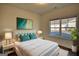A bedroom with a large window, nice lamps, hardwood floors, and modern art on the wall at 2929 Rambler Dr, Loganville, GA 30052
