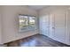 Bright bedroom featuring hardwood floors, a large window with trim, and a double door closet at 2929 Rambler Dr, Loganville, GA 30052