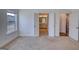 Unfurnished bedroom featuring neutral walls and carpeting with an attached bathroom and access to the kitchen at 2929 Rambler Dr, Loganville, GA 30052