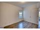 Bedroom with hardwood floors, neutral walls, white trim, a window, and a door at 2929 Rambler Dr, Loganville, GA 30052