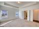 Unfurnished bedroom with neutral walls and carpeting and featuring tray ceiling and an attached bathroom at 2929 Rambler Dr, Loganville, GA 30052