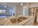 Kitchen island boasting a stainless sink with a view of the living room and fireplace at 2929 Rambler Dr, Loganville, GA 30052