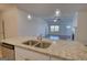 Kitchen island featuring stainless steel sink and hardware with view into the living room at 2929 Rambler Dr, Loganville, GA 30052