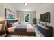 Bedroom with a king-size bed, large TV, blue and gray color scheme, and a plant by the window at 1555 South Bethany Rd, Locust Grove, GA 30248