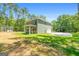 Side view of a two-story green home with a concrete driveway, a covered patio, and a well-manicured lawn at 1555 South Bethany Rd, Locust Grove, GA 30248