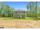 Back exterior of a two-story green home with a well manicured yard on a sunny day at 1555 South Bethany Rd, Locust Grove, GA 30248