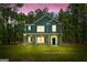 A beautiful two-story home with a front porch, green siding, dark shutters, and a well-kept lawn at 1555 South Bethany Rd, Locust Grove, GA 30248