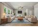 Bright living room features large windows, a ceiling fan, and neutral decor perfect for relaxation and entertaining at 1555 South Bethany Rd, Locust Grove, GA 30248
