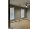 Empty bedroom with neutral walls, carpet flooring, ceiling fan and two windows at 2200 Hickory Station Cir, Snellville, GA 30078