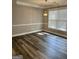 Dining room features wood flooring, a modern light fixture, a window, and neutral wall paint at 2200 Hickory Station Cir, Snellville, GA 30078