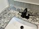 Close up view of a bathroom sink with granite countertops and a black faucet at 1681 Stanton Sw Rd, Atlanta, GA 30311