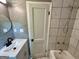 Small bathroom with a sleek sink, toilet and tub with tiled walls at 1681 Stanton Sw Rd, Atlanta, GA 30311