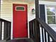 Close-up of the front door, painted in a striking red color with a charming porch light at 1681 Stanton Sw Rd, Atlanta, GA 30311