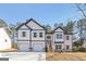 Charming two-story home featuring a two-car garage, stone accents, and a welcoming entrance with wooden steps at 3278 Greenhill Dr, Villa Rica, GA 30180