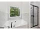 Relaxing soaking tub and glass enclosed shower offer backyard views at 2279 Lakeview Pkwy, Villa Rica, GA 30180