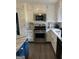 White and blue kitchen equipped with stainless steel appliances and subway tile backsplash at 5526 Stoneleigh Court, Stone Mountain, GA 30088
