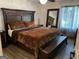 A primary bedroom featuring a large wooden headboard, window, and full-length mirror at 5526 Stoneleigh Court, Stone Mountain, GA 30088