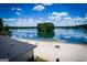 Sandy beach with picnic tables and lifeguard chairs overlooking the tranquil lake and a distant island at 3279 Greenhill Dr, Villa Rica, GA 30180