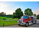 A vibrant red firetruck parked on a lush green lawn against a backdrop of trees and a clear blue sky at 3279 Greenhill Dr, Villa Rica, GA 30180