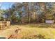 Large backyard featuring a wooden deck, mature trees, and shed at 75 Antioch Rd, Mcdonough, GA 30252