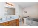 Bathroom features a vanity with sink, a window, bathtub and toilet with tiled flooring at 75 Antioch Rd, Mcdonough, GA 30252