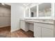 Well-lit bathroom with dual sinks, granite countertops, wood-look floors, and access to a walk-in closet at 768 Great Oak Place # 26, Villa Rica, GA 30180
