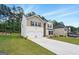 Well maintained home with a long driveway, manicured lawn, and a lush tree line in the background at 768 Great Oak Place # 26, Villa Rica, GA 30180