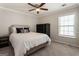 Cozy bedroom featuring a queen-sized bed, ceiling fan, and natural light at 169 Wallnut Hall Cir, Woodstock, GA 30189
