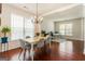 Elegant dining room with a chandelier, hardwood floors, and bright natural light at 169 Wallnut Hall Cir, Woodstock, GA 30189