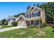 Charming two-story home with a well-manicured lawn, two-car garage, and inviting front porch seating at 169 Wallnut Hall Cir, Woodstock, GA 30189