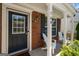Inviting front porch with brick accents, comfortable seating, and a charming blue front door at 169 Wallnut Hall Cir, Woodstock, GA 30189
