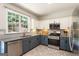 Modern kitchen with sleek stainless-steel appliances, stylish blue and white cabinets, and tile floors at 169 Wallnut Hall Cir, Woodstock, GA 30189