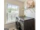 Laundry room with front-loading washer and dryer and bright window at 169 Wallnut Hall Cir, Woodstock, GA 30189