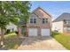 Charming two-story brick home featuring a well-manicured lawn, two-car garage, and stone accents at 11657 Flemming Ct, Hampton, GA 30228
