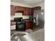 Well-equipped kitchen featuring stainless steel appliances, dark cabinets, and granite countertops at 11657 Flemming Ct, Hampton, GA 30228