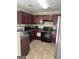 Functional kitchen with dark wood cabinets and sleek black appliances at 11657 Flemming Ct, Hampton, GA 30228
