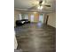 Spacious living room features vinyl flooring, black sofa, and natural light from the windows at 11657 Flemming Ct, Hampton, GA 30228