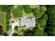 Aerial view of the house with a gray roof, surrounded by trees, and multiple cars in the driveway at 78 N Pomona Rd, Hampton, GA 30228