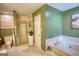 Bright bathroom featuring a built-in tub, a separate shower, and a cabinet with storage at 78 N Pomona Rd, Hampton, GA 30228