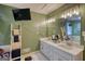 Bathroom with dual sink vanity, decorative mirror, and a wall-mounted television at 78 N Pomona Rd, Hampton, GA 30228