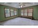 Bright bedroom features three large windows, green walls, and a bench to sit and look out onto the yard at 78 N Pomona Rd, Hampton, GA 30228