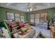 Cluttered living room with carpeted floor, wood trim, large windows, and ceiling fan with light fixture at 78 N Pomona Rd, Hampton, GA 30228