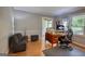 Well-lit office space featuring a wooden desk, a comfortable chair, and cozy gray sofa at 78 N Pomona Rd, Hampton, GA 30228