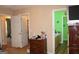 View of the bedroom and bathroom with a wooden dresser with decor on top, and two open doorways at 239 Ferguson Ave, Locust Grove, GA 30248