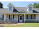 Inviting covered front porch with white railings and rocking chairs, creating a cozy curb appeal at 239 Ferguson Ave, Locust Grove, GA 30248