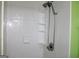 Bright shower area with white tiles, shelving for storage, and a shower head with a flexible hose at 239 Ferguson Ave, Locust Grove, GA 30248
