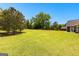 Expansive backyard showcasing a well-manicured lawn and beautiful, mature trees at 125 Lake Park Dr, Sharpsburg, GA 30277