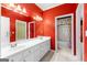 Bright red bathroom with double vanity, gold hardware, and tile flooring at 125 Lake Park Dr, Sharpsburg, GA 30277