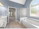 Well-lit bathroom featuring a soaking tub with separate shower and tile floors at 125 Lake Park Dr, Sharpsburg, GA 30277